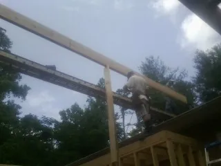 Carpenter setting a ridge beam over a new addition frame — Ice Dam Removal by Roofing Brothers in Moore